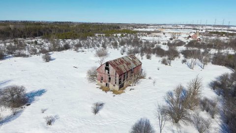 Aerial footage around old red barn in Canadian forest.