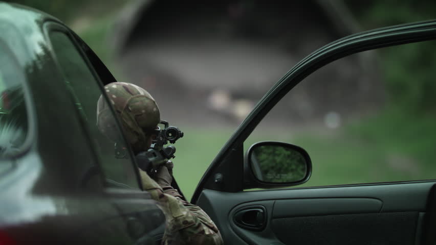 Shooting from a car, a policeman shoots a rifle. Fully equipped policeman, Slow Motion 4K UHD.