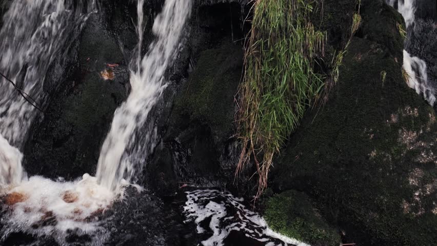Tilt up shot to a divergent waterfall, rapid int he Wicklow mountains Ireland