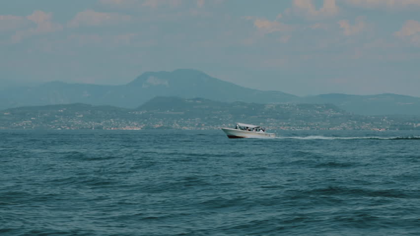 Marine Landscape. Boat At Speed. Mountains In The Background.