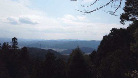 A pan shot of a beautiful mountain view on a rural trail in Japan.