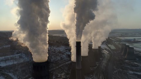 Winter epic pipes factory thick white smoke steam sunset dark silhouette  production chemical industry buildings cityscape. Ecology pollution exhaust. Russia north Siberia 4k Drone forward 