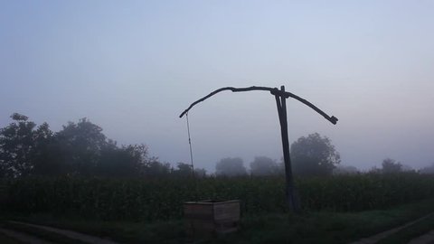 Still timelapse of a shadoof in the foggy morning.