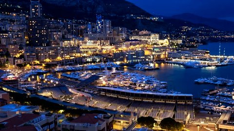 Timelapse of Monaco Monte Carlo harbour and city skyline in the evening. Monaco Port night view with fast moving clouds