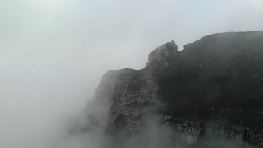 Aerial view of the top of a rocky plateau enveloped by fog and mist in the North Caucasus mountain region of Russia