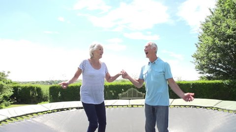 Slow motion sequence of senior couple bouncing on trampoline. Shot on Sony FS700 at frame rate of 100fps