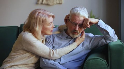 Caring understanding middle aged wife embracing comforting talking to upset grey haired elderly husband share problem give empathy love and compassion, old senior retired couple psychological support
