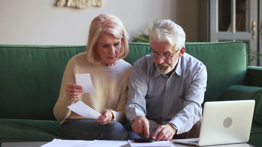 Worried senior old couple stressed about paperwork discuss unpaid bank debt holding bills check expenses, retired aged family read loan payments documents talking at home anxious about money problems Royalty-Free Stock Footage #1028900216