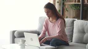 Serious happy young woman typing on laptop browsing chatting in internet use app sit on sofa, smiling focused millennial girl working studying on laptop surfing web looking at computer screen at home - Powered by Shutterstock - Get 15% off with code: PIKWIZARD15