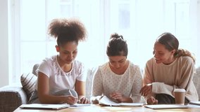Three diverse teen girls preparing for test exam writing essay coursework studying at home together, teenager college students friends doing research assignment making notes talking laughing learning - Powered by Shutterstock - Get 15% off with code: PIKWIZARD15
