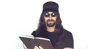 Portrait of a brunette man with a long curly hair, beard and mustache in sunglasses on a white background. Man reading diary