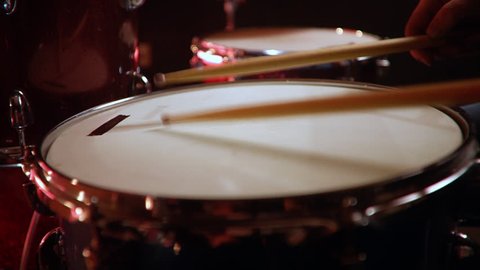 drummer, jazz lesson , standart drumsticks , drumroll on a snare  a rehearsal studio on a red drums , low key, close-up
