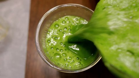 Pouring Organic Freshly Squeezed Green Vegetable and Fruit Juice Into the Glass