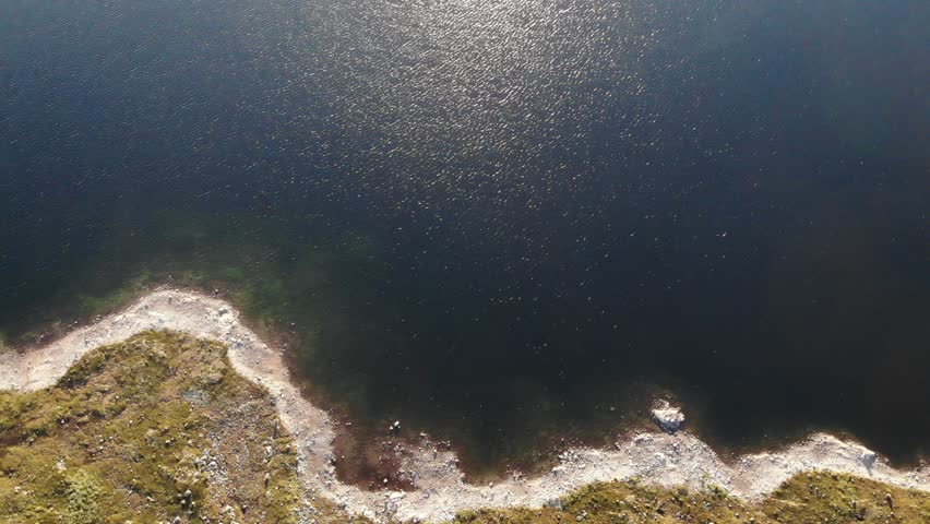 Aerial view. Clear blue sea water with stone rocky fjord shore. Norwegian nature.