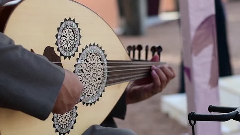 Arabic musician from Saudi Arabia plays music on traditional instrument from Middle East called Oud or Ud.