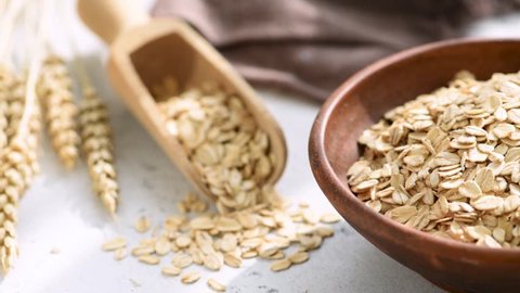 Oats, Rolled oats or oat flakes in bowl. Healthy eating, dieting, weight loss food concept. Closeup view.