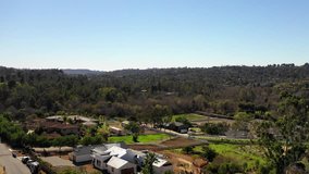 Aerial drone video over beautiful Encinitas, California neighborhood of Olivenhain, on a sunny day.