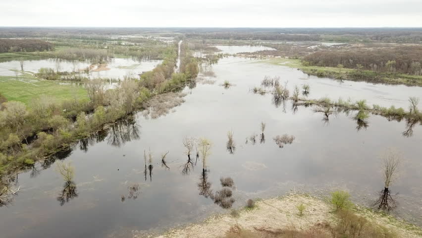 Grand river watershed. Aerial Drone footage of river flooded marsh land. Trees reflected on the water. Grand river Michigan.