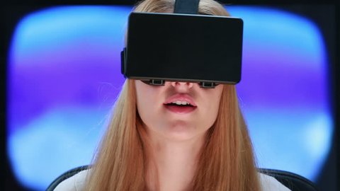 Virtual reality game. Girl with pleasure uses head-mounted display.
