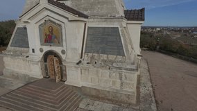 Shooting from Saint Nicholas church in the shape of a pyramid at the Brotherhood cemetery on the Northern side of Sevastopol bay, details of facade, entrance to cathedral, mosaic image