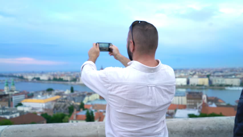 Young man taking photo of Budapest cityscape