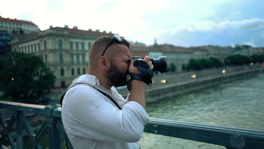 Young man taking photo with digital camera in Budapest city