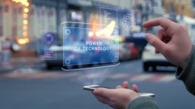 Female hands on street interact with HUD hologram with text Power of technology. Woman uses the holographic technology of future in smartphone screen on background of evening city - Powered by Shutterstock - Get 15% off with code: PIKWIZARD15