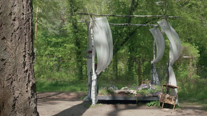 A wide shot of a artistic flower bed in form of a four poster bed in the forest