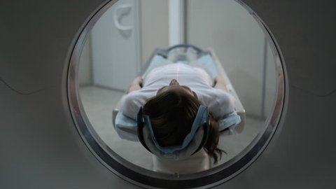 Female Patient On The Ct Or Mri Scanner Machine During X-Ray Process,