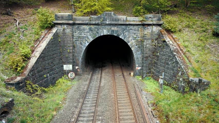 A passenger train passes through the Totley tunnel in the Peak District during May - Sunny overcast day