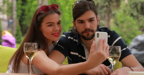 Couple date, man and woman make selfie sitting at the table