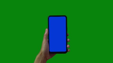 Phone in the hand close up isolated at green background. Phone screen is blue chroma key, background chroma key green screen. Footage for mobile ads, app promo.