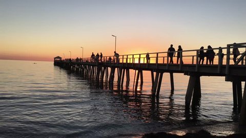 ADELAIDE - MAY 06 2019: Silhouette of Henley Beach pier at dusk. Henley Beach pier is a very popular tourist attraction and sightseeing in Adelaide the capital city of South Australia.