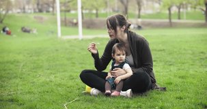 Mother blowing bubbles with baby girl. Cinematic 4K footage.
