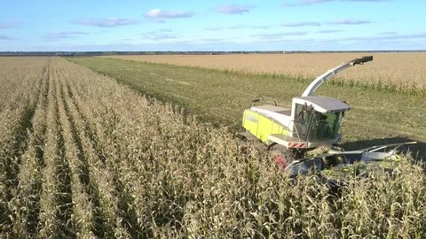 close motion above field modern highly efficient forage harvester with transparent cabine against pictorial nature