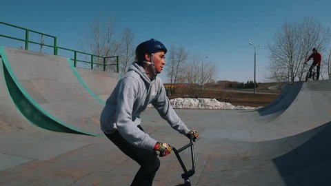 A BMX rider riding on ramps and performing tricks in the skatepark స్టాక్ వీడియో