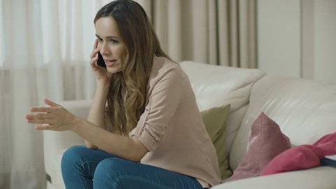 Angry woman talking phone at home. Portrait of upset person call mobile phone indoors. Stress woman using cellphone. Frustrated lady scream smartphone at home. Disappointed customer arguing on phone
