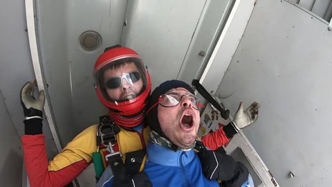 Tandem skydiving. Two men are jumping out of the plane.