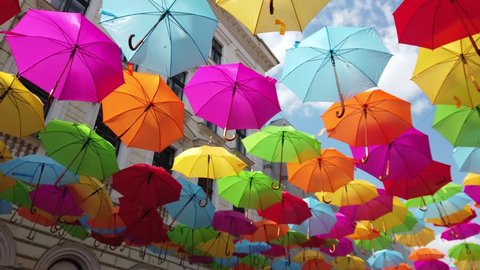 colored umbrellas are swinging in the wind : vidéo de stock