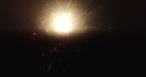 Bizarre flashes of fireworks in the cloudy night sky. The camera shoots from the air from a short distance. Beautiful night show.