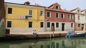 European teen girls are chatting outdoor at summer day in Murano, Veneto, Italy.