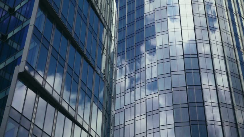 Modern Business Office Buildings with Glass Reflection. Time lapse of clouds reflecting onto the glass of a large office building. Reflection of clouds in a modern skyscraper.  | Shutterstock HD Video #1029027134