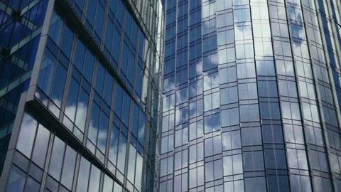 Modern Business Office Buildings with Glass Reflection. Time lapse of clouds reflecting onto the glass of a large office building. Reflection of clouds in a modern skyscraper. 