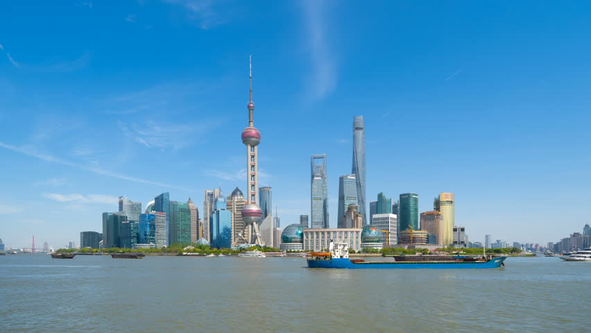 Time lapse of Shanghai Downtown skyline by Huangpu River, China. Financial district and business centers in smart city in Asia. Skyscraper and high-rise buildings near The Bund at noon.