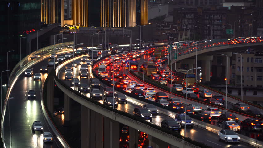 Traffic jam in the rush hour on highway. Cars on bridges and roads in Shanghai Downtown, China at night.