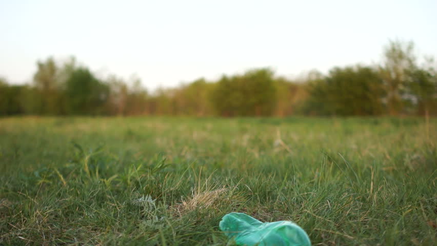 Close plan the hand of a volunteer picks up a plastic bottle from the grass in the park. stop plastic, social concept, civil liability, environmental concept Royalty-Free Stock Footage #1029033440