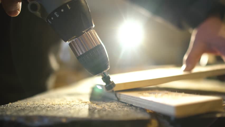 Close up of Wood Worker using an electric hand drill to drill a hole through the bracket. Royalty-Free Stock Footage #1029044804