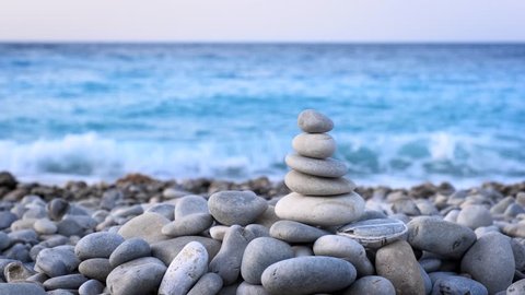 Zen meditation background - balanced stones stack cairn close up on sea beach