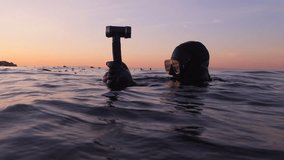 A Scuba Diver Scans the Surface of Ocean at Sunset in Monterey, CA