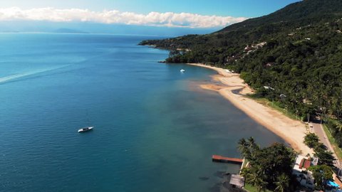 Aerial: Gorgeous Blue Water and Rich Green Jungle Along Coastline in Ilhabela, Brazil
